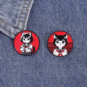 Gros plan de deux épingles en émail de chat japonais sur fond en tissu denim bleu