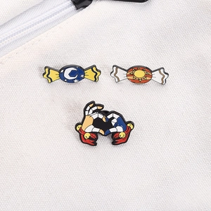Detailed view of anime enamel pins featuring moon and sun candy motifs on white canvas