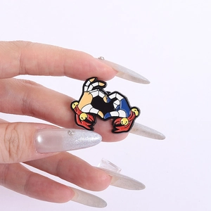 Detailed close-up of heart gesture enamel pin with colorful cartoon hand design