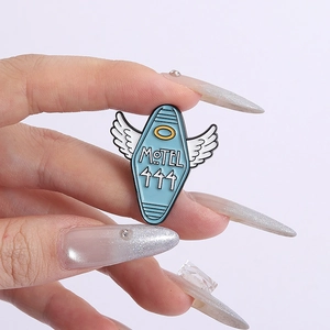 Blue enamel Motel 444 motel keychain brooch with white wings and golden halo detail