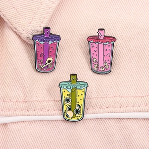Macro detail of alloy enamel pins featuring quirky eyeball and skeleton bubble tea designs