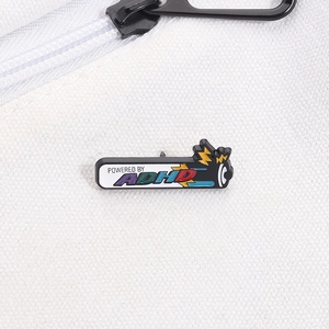 Close-up of Power by ADHD battery enamel pin pinned on a white canvas bag strap