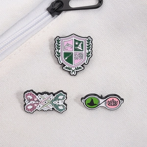 Detail of three-piece enamel brooch set featuring magic shield and scissors on canvas bag