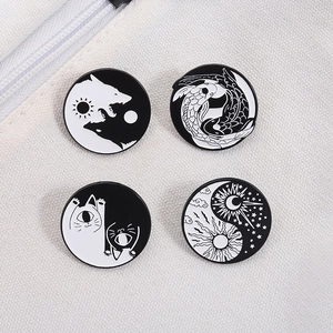 Détail de quatre épingles en émail Yin Yang noir et blanc avec motifs de loup et carpe koi