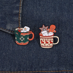 Christmas enamel pins set featuring marshmallow gingerbread man and snowman mugs on denim