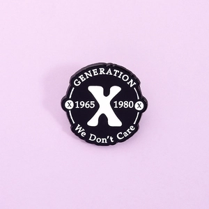 Nahaufnahme der Generation X Emaille-Anstecknadel mit weißem Text auf schwarzem Grund