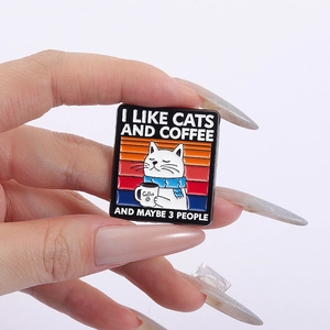 Detailed macro view of cat and coffee enamel pin featuring humorous text on clothing