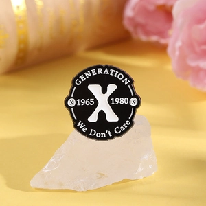 Detail der Generation X Emaille-Anstecknadel mit dem Spruch We Don't Care auf Metallbasis