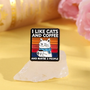 Macro detail of enamel cat brooch with I Like Cats and Coffee text on floral background