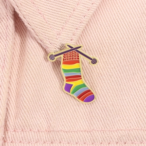 Rainbow striped knitting sock enamel brooch pinned on pink denim fabric collar
