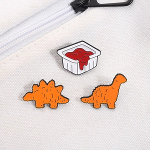 Three-piece dinosaur chicken nugget enamel pin set with tomato sauce on canvas bag