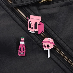 Close-up of pink skull drink and lollipop enamel pins styled on a black leather jacket