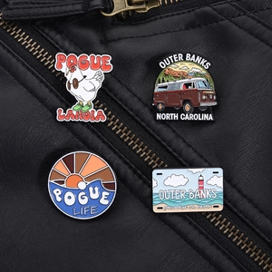 Detailed set of Outer Banks enamel pins on leather jacket showing retro van and rooster badge