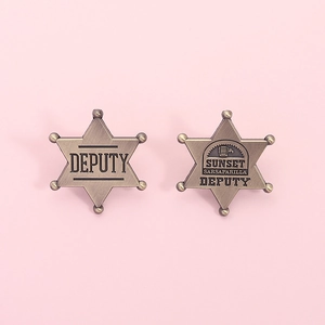 Detail view of retro bronze star badges with Deputy and Sunset Sarsaparilla engravings