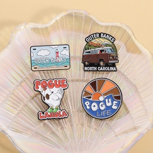 Set of four Outer Banks themed enamel pins with a camper van and chicken badge