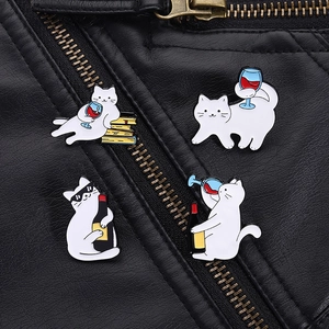 Detail of four funny white cat enamel pins featuring wine elements on a black leather jacket