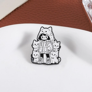 Pin's émaillé noir et blanc avec une fille en sweat à oreilles de chat et quatre petits chats