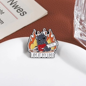 Cartoon black cat enamel pin with chainsaw and flame detail on white plate background