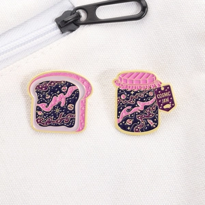 Détail de broches émaillées Cosmic Jam avec pain étoilé pailleté et design de pot de confiture