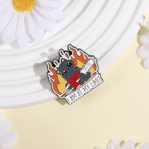 Funny black cat enamel pin with chainsaw and flames on white display pedestal
