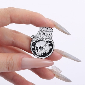 Macro detail of gothic skull potion bottle enamel pin with black and white contrast