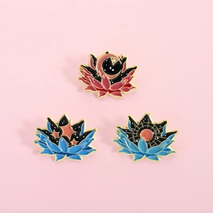Gros plan de trois pin's lotus célestes en émail avec motifs lune et étoiles sur métal
