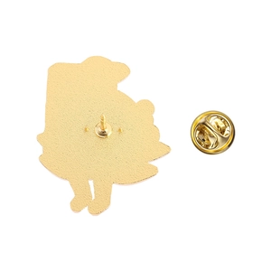 Détail de l'arrière d'un pin's doré avec fermoir papillon et base en métal texturé