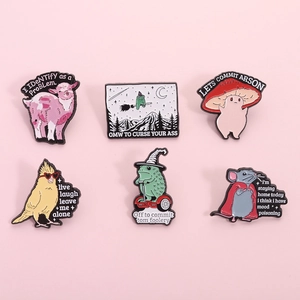 Collection of quirky enamel animal pins including goats, frogs and mushrooms