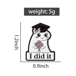 Close-up of ghost enamel pin with graduation cap, pink flowers and 'I did it' banner