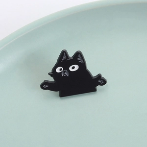 Creative black cat enamel pin with shrug pose and cute paw details on a mint green tray