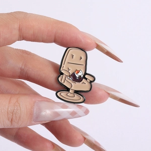 Détail d'un pin's en émail créatif représentant un chat sur une chaise de bureau