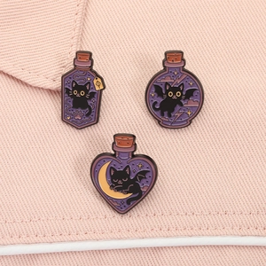 Detailed macro view of three enamel black cat and purple potion bottle brooches