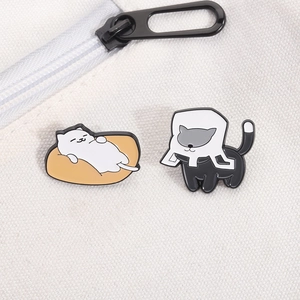 Close-up of cute cartoon enamel cat pins on white canvas bag with zipper detail