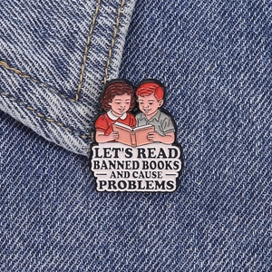 Detail der Let's Read Banned Books Emaille-Anstecknadel auf blauem Denim-Stoffgewebe