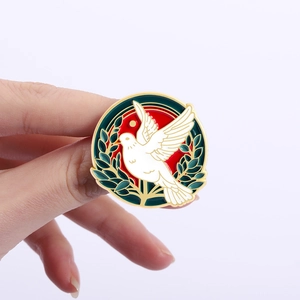 Vintage peace dove enamel pin featuring a white bird with olive branches and red sun background