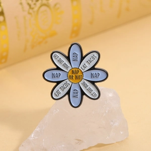Close-up of blue and white daisy enamel brooch with funny English slogan on a white stone