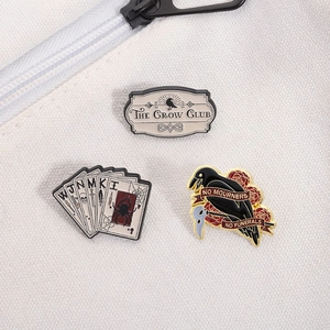 Détail de l'ensemble de pins Six of Crows avec logo The Crow Club et cartes de poker
