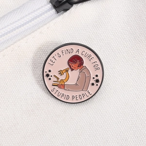 Close-up of a science enamel pin on a white canvas bag featuring a microscope design