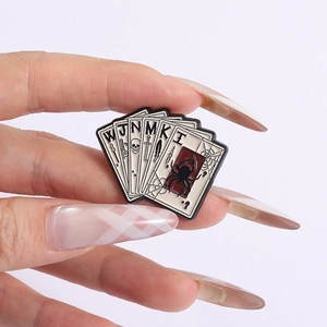 Vue rapprochée de la broche gothique en émail avec cartes de poker et détails de crâne