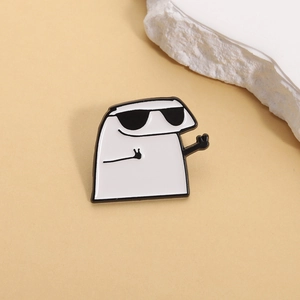 Close-up of cool cartoon white enamel pin wearing sunglasses with peace signs