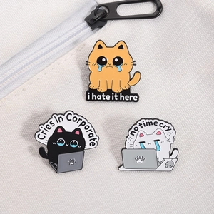 Detailed view of three enamel cat pins on a canvas bag featuring corporate humor quotes