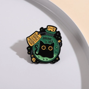 Detailed enamel pin showing a black cat in a poison bottle with Drink Me text label