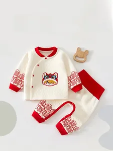 Close-up of quilted baby winter set with red trim and traditional lion dance embroidery