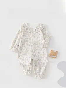 Detailed close-up of floral baby romper featuring frill collar and soft cotton fabric