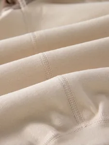 Body bébé beige avec coutures plates douces à quatre aiguilles et six fils confortables