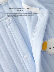 Detail of eco-friendly resin snap buttons on light blue ribbed cotton baby romper