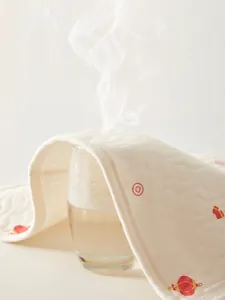 Quilted white baby sweat pad with red lantern pattern showing steam for high breathability
