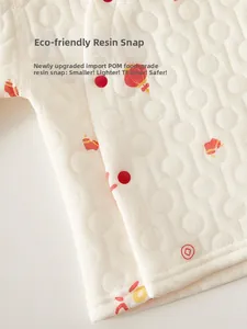 Close-up of baby quilted bodysuit with eco-friendly red resin snaps and lantern print