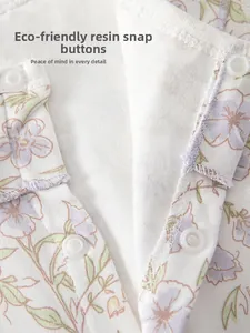 Detail of eco-friendly resin snap buttons on cotton floral baby romper fabric
