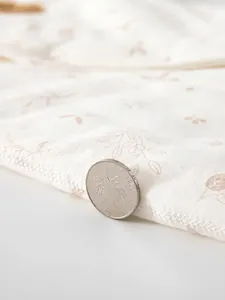 Barboteuse bébé en coton ouatiné avec imprimé feuilles montrant le tissu thermique épais